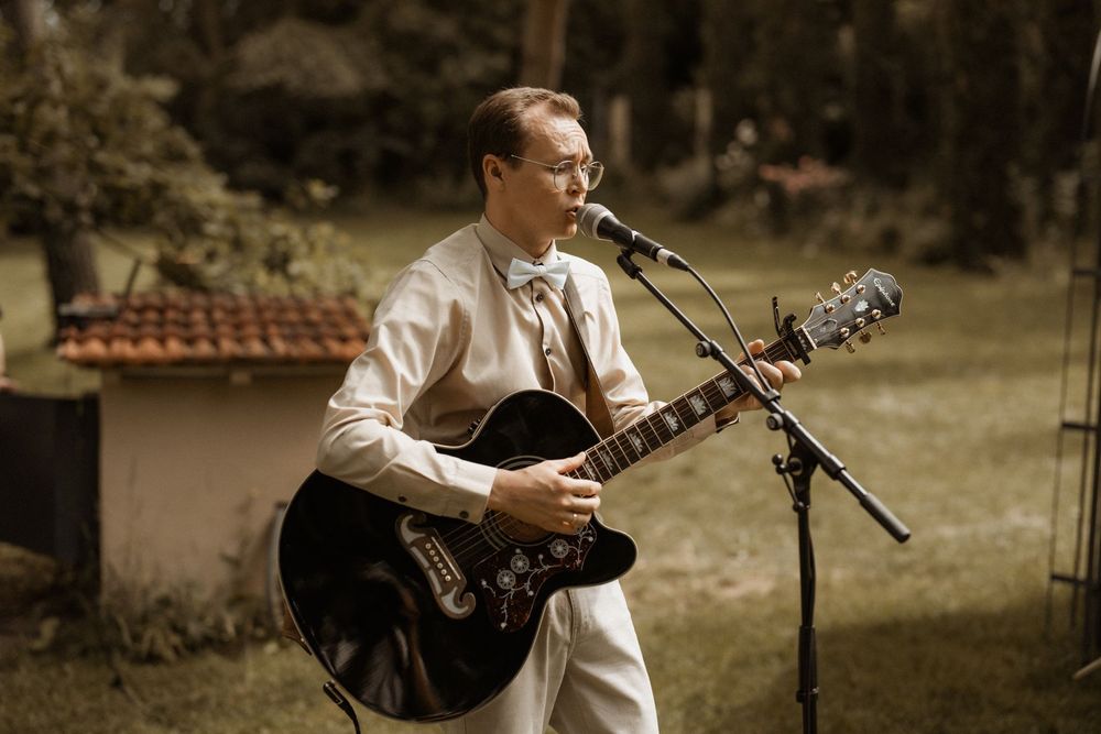 Trauredner mit Gitarre bei einer Trauung unter freiem Himmel